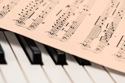 sheet music layed out over piano keys